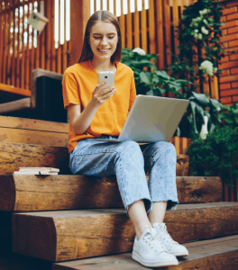 Woman working on phone and laptop