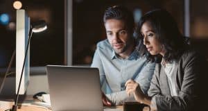 Two colleagues looking at a laptop